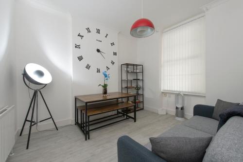 a living room with a couch and a clock on the wall at Tower Bridge Exclusive Two bedroom apartment in London