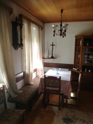 a dining room with a table and a cross on the wall at Rooms / Sobe Šolar - Brezje in Brezje