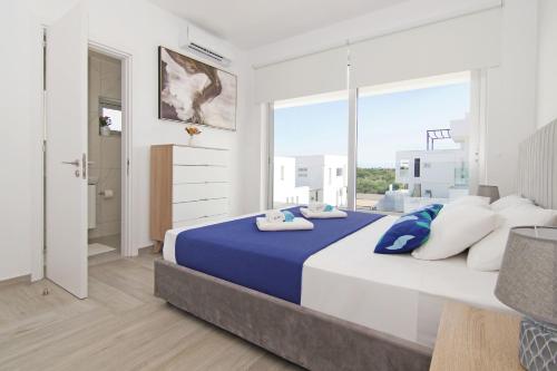 ein Schlafzimmer mit einem großen Bett und einem großen Fenster in der Unterkunft Villa Amelia in Paralimni