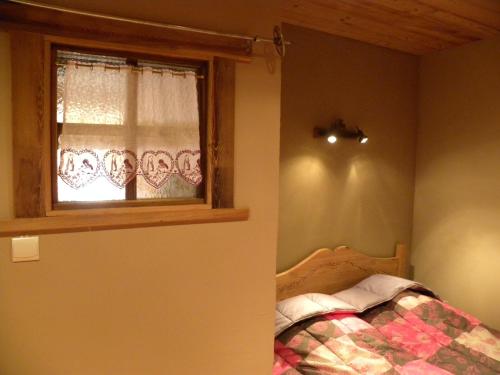 a bedroom with a bed and a window at La Poya in Valloire