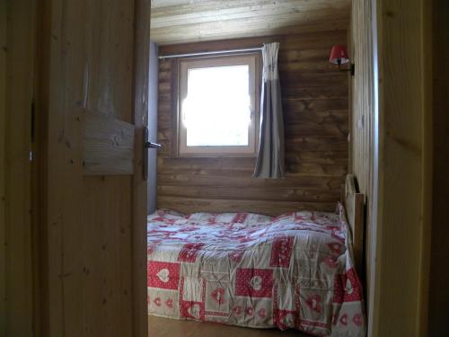 a bedroom with a bed with a window in it at La Poya in Valloire