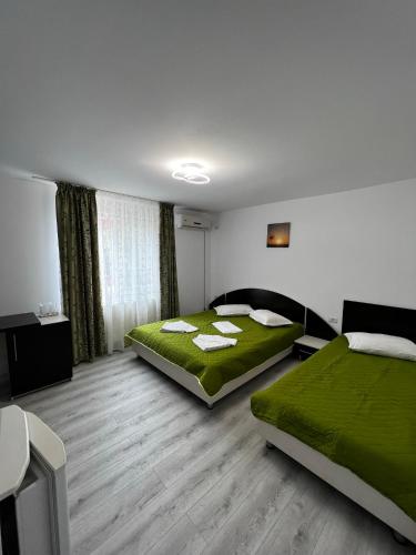 um quarto de hotel com duas camas e um sofá em Vila Iris Mamaia Nord em Mamaia Nord – Năvodari