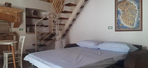 a bedroom with a bed and a spiral staircase at Casa vacanze salento Vicosoluna in Morciano di Leuca