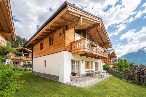 a house in the mountains with a balcony at Chaletdorf am Sonnenhang in Neukirchen am Großvenediger