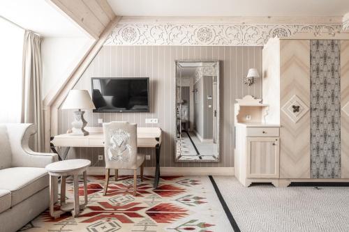 a living room with a desk and a mirror at Aries Hotel & SPA Zakopane in Zakopane
