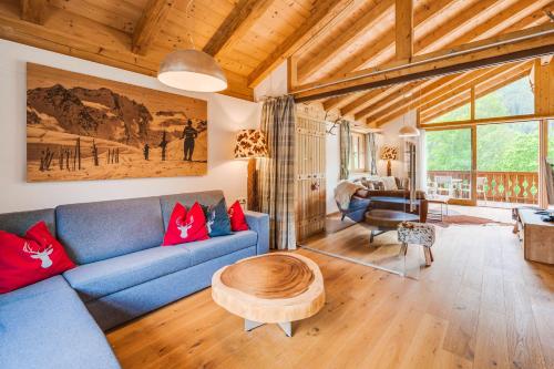 a living room with a blue couch and a table at Chaletdorf am Sonnenhang in Neukirchen am Großvenediger