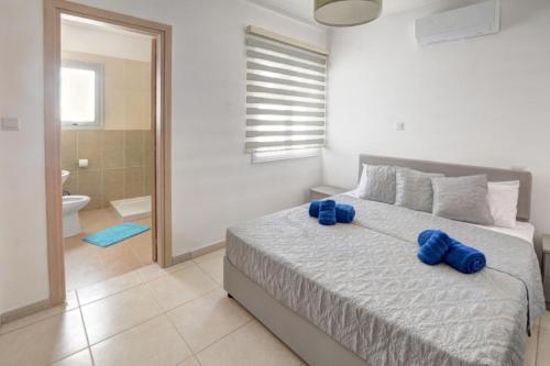een slaapkamer met een bed met blauwe kussens erop bij Nissi Villa Sotia in Ayia Napa