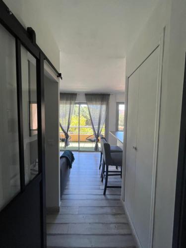 um corredor que leva a uma sala de estar com uma mesa em Chez Mel et Manu em Sanary-sur-Mer