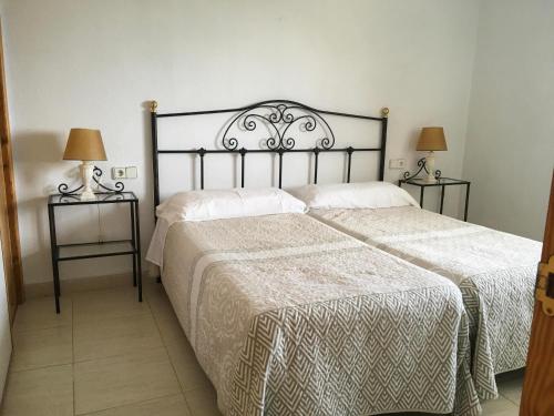 a bedroom with two beds and two lamps on tables at Apartamentos Bahia in Benidorm