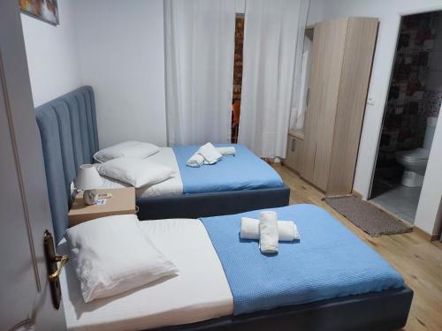 two beds in a room with towels on them at Lazaris kwstas Rooms in Himare