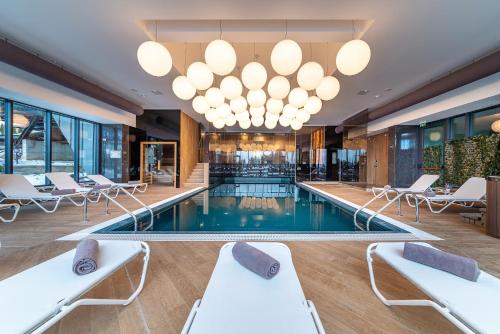 a hotel lobby with a swimming pool and chairs at Complex Hotelier COTA O MIE in Sinaia