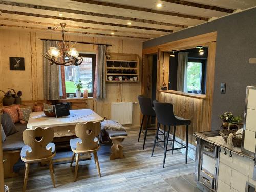 a kitchen and living room with a table and chairs at Chalet am Weißenbach in Hinterstoder