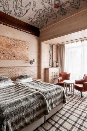 a bedroom with a bed and a table and a chair at Aries Hotel & SPA Zakopane in Zakopane