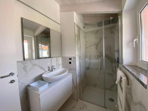 y baño blanco con lavabo y ducha. en Royal apt Colico Lake Como, en Colico
