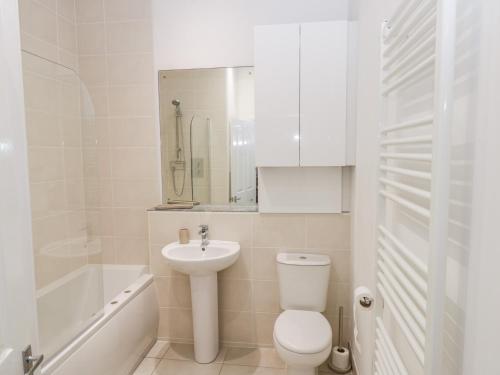 a white bathroom with a toilet and a sink at Bluewater View in Saltburn-by-the-Sea