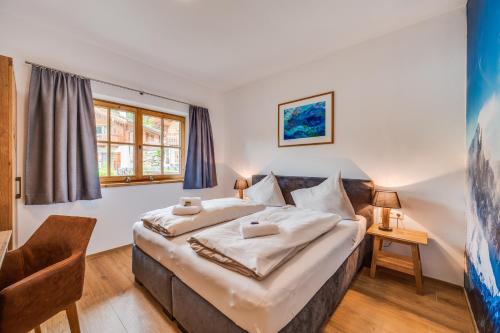 a bedroom with a large bed in a room at Chaletdorf am Sonnenhang in Neukirchen am Großvenediger