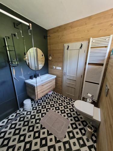 a bathroom with a sink and a toilet and a mirror at Artur Apartment Myto in Mýto pod Ďumbierom