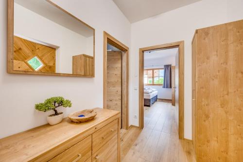 a room with a wooden dresser and a mirror at Chaletdorf am Sonnenhang in Neukirchen am Großvenediger