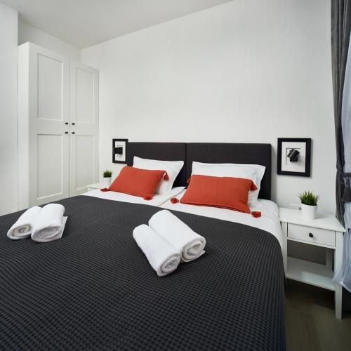 a bedroom with two beds with red and white pillows at Cardo Apartments in Poreč