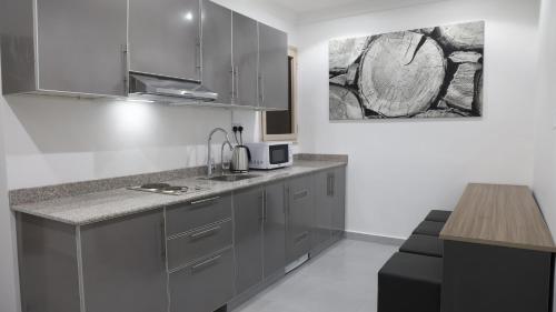 a kitchen with gray cabinets and a counter top at BHomed Furnished Apartments in Kuwait