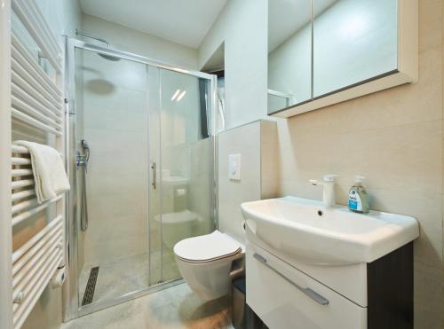 a bathroom with a toilet and a sink and a shower at Cardo Apartments in Poreč
