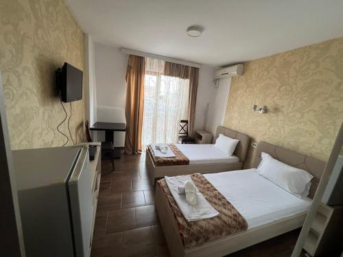 a hotel room with two beds and a television at Hotel Ultra Star in Skopje