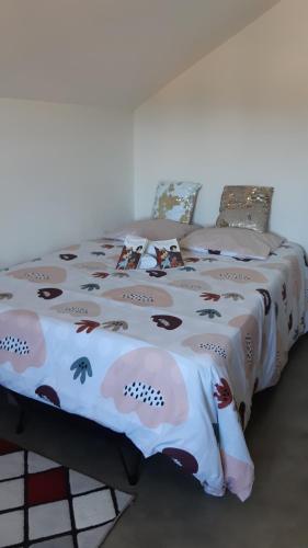 a bed with a comforter with animals on it at LOCATIONS VERT EDEN in La Plaine des Cafres