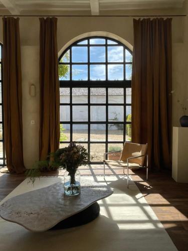 sala de estar con mesa y ventana grande en guesthouse L'Officine en Lincent