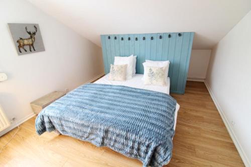 a bedroom with a bed with a blue headboard at Maison de caractère à Gérardmer avec sauna et spa in Gérardmer