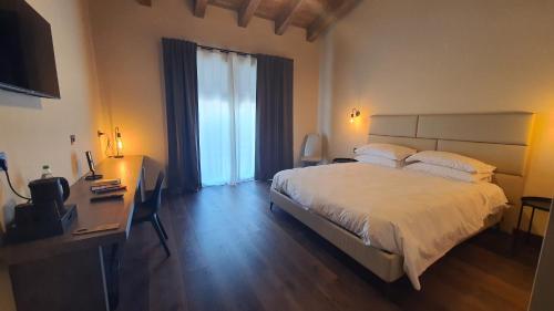 a bedroom with a large bed with a desk and a window at ORIZZONTI Vigneti Repetto in Sarezzano