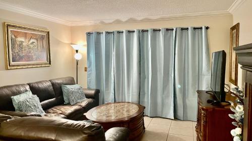 a living room with a leather couch and a table at lovely 2BED 2BA vacation rental near the Beach in Pompano Beach
