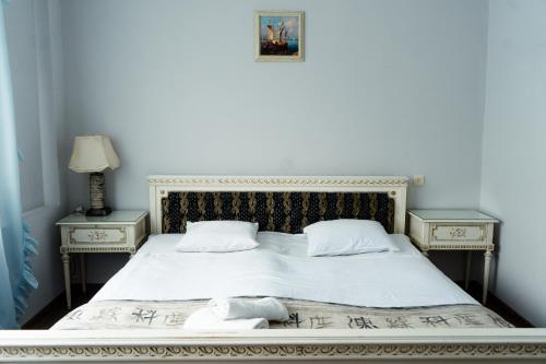 Hotel White House في تبليسي: سرير ابيض و طاولتين