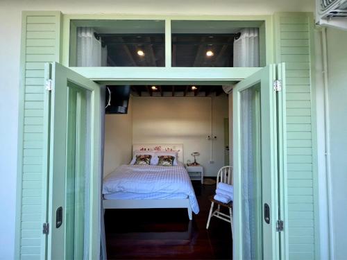 Una cama o camas en una habitación de Zane Balcony House Ranong Hotel เซน บัลโคนี่ เฮ้าส์ ระนอง