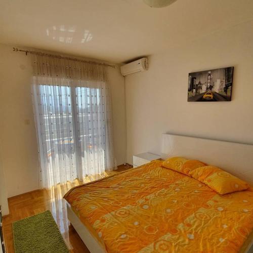 a bedroom with a bed and a large window at Apartman Nadja in Budva