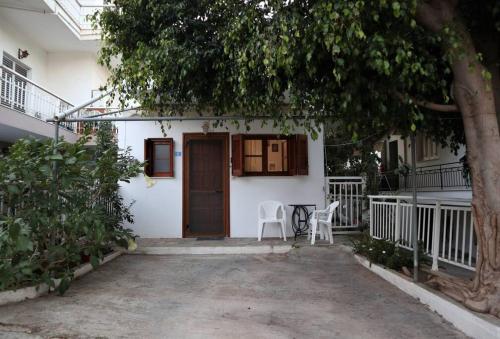 ein weißes Haus mit zwei Stühlen und einer Tür in der Unterkunft Sophie's traditional hospitality appartment in Monemvasia