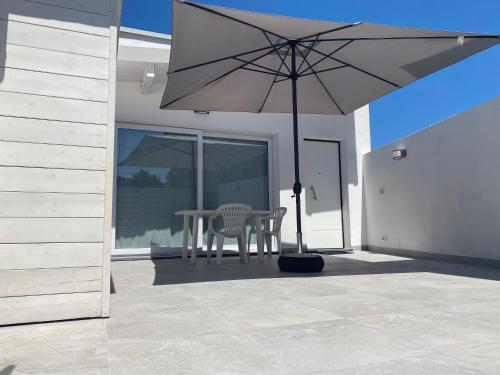 un patio avec une table et un parasol dans l'établissement Dimora Maria Elena, à Pescara