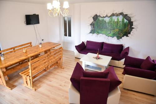 a living room with purple couches and a table at Manana Guesthouse in Marmarik