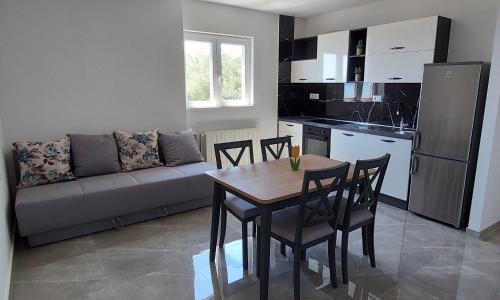 a kitchen and a table and chairs in a living room at Apartman Dado Podgora in Podgora