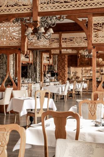 a restaurant with white tables and chairs at Aries Hotel & SPA Zakopane in Zakopane