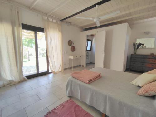 a bedroom with a bed and a large window at Il Casale in Teulada