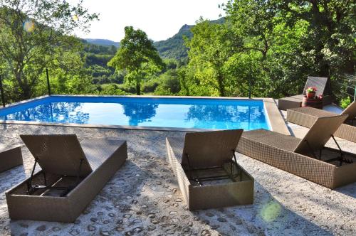 una piscina con due sedie a sdraio e una piscina di Traditional Stone House Kotli a Buzet (Pinguente)