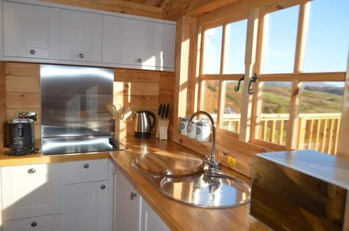 a kitchen with a sink and a window in a cabin at Seillean Trang in Saasaig