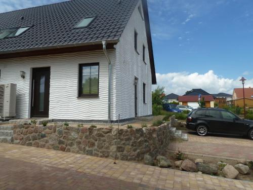 a house with a car parked in front of it at Ferienwohnung Kargoll Wydra in Heringsdorf in Heringsdorf