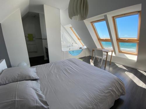 1 dormitorio con cama, mesa y ventana en Villa de la plage de Plouescat, en Plouescat