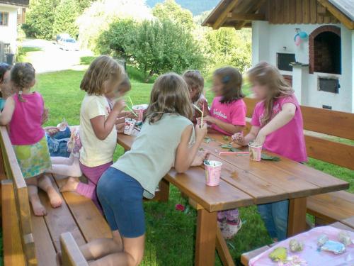 un grupo de chicas sentadas en una mesa de picnic en Apartment Enzian by Interhome, en Arriach