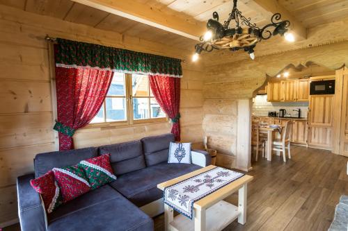 salon z kanapą i stołem w obiekcie Bajkowa Osada Murzasichle domek z jacuzzi w Murzasichlu