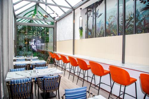 a dining room with orange chairs and tables at Dosso Dossi Hotels Yenikapı in Istanbul