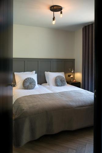a bedroom with a large bed with two pillows at Holiday home de Stamhoeve in Biezenmortel