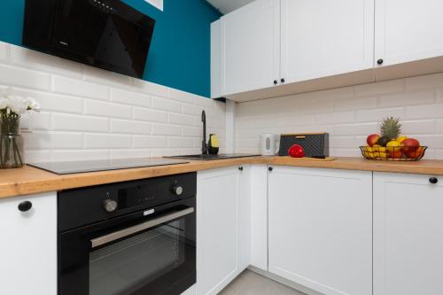 a kitchen with white cabinets and a black oven at Warsaw Center Capitol Apartment by Renters in Warsaw
