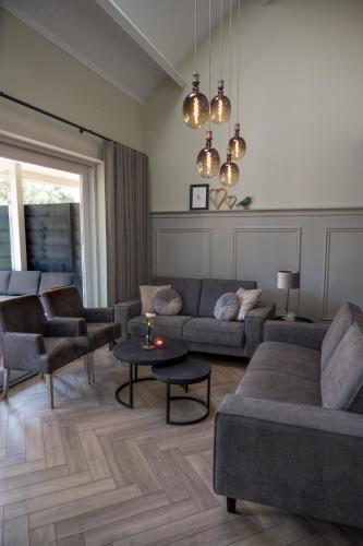 a living room with a couch and chairs and a table at Holiday home de Stamhoeve in Biezenmortel
